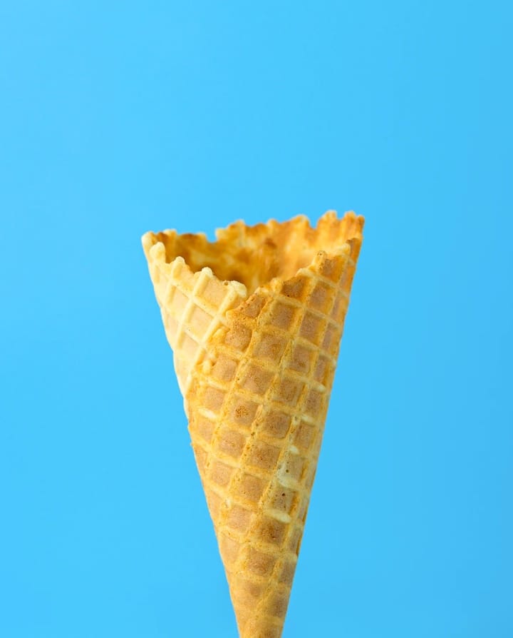 Picture of a ice cream cone without ice cream on a blue color background